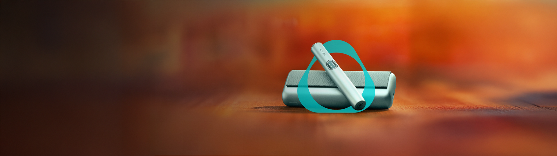 Dispositivo IQOS ILUMA i PRIME Azul Claro sobre carregador de bolso, em x, sobrepostos com logótipo IQOS e em fundo desfocado.
